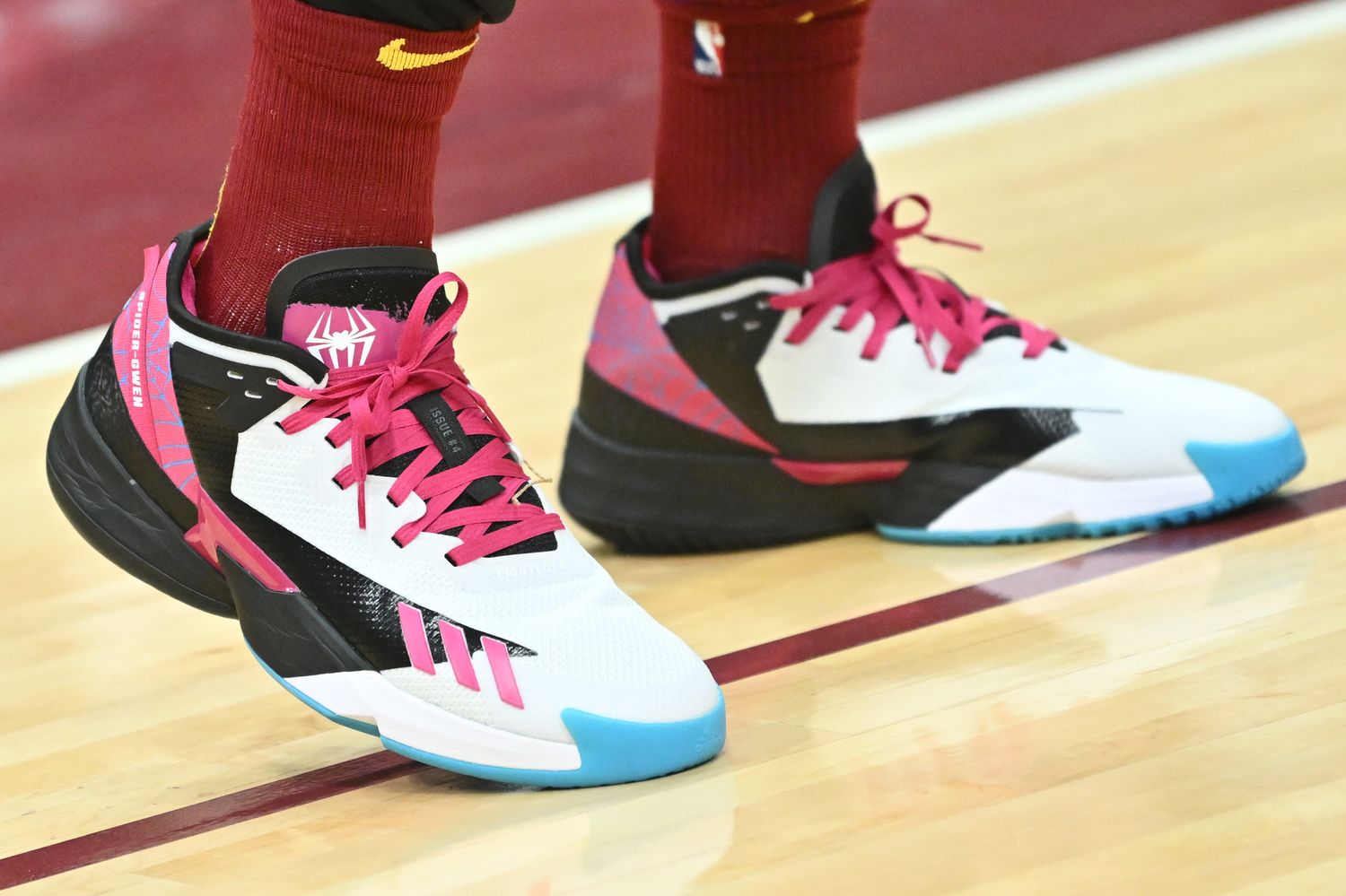 View of white, black, and pink adidas shoes.